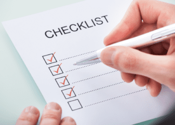 Hand marking off items in a checklist
