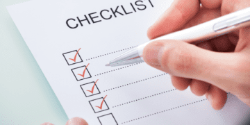 Hand marking off items in a checklist
