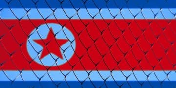 flag of North Korea behind chain link fence