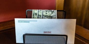 bribe beside college admissions envelope