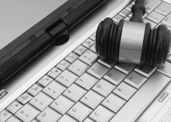 judge's gavel on silver laptop