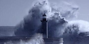 giant waves crashing around lighthouse in a storm