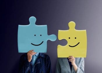 two businesspeople with puzzle pieces as heads