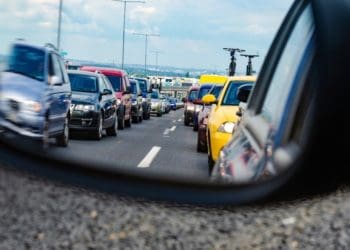 traffic seen through car's side mirror