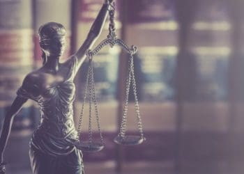 scales of justice against legal library background