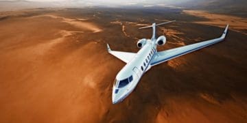 top view of small charter plane flying over desert