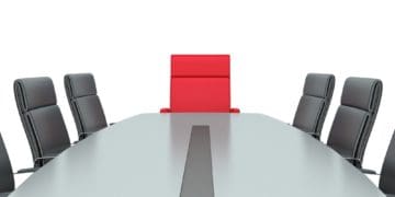 red, empty chair at board room table