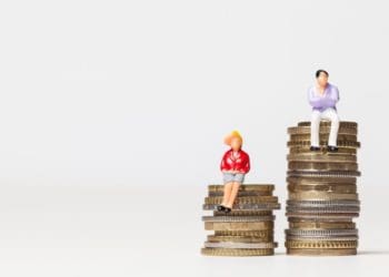 male and female figurines sitting on stacks of coins