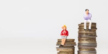 male and female figurines sitting on stacks of coins