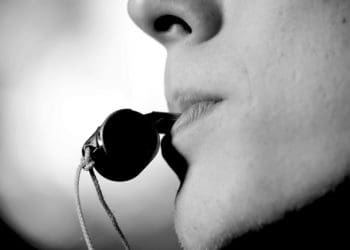 black and white image of man blowing a whistle