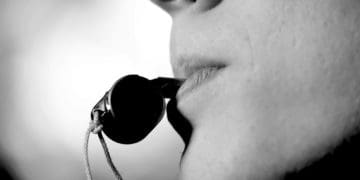 black and white image of man blowing a whistle