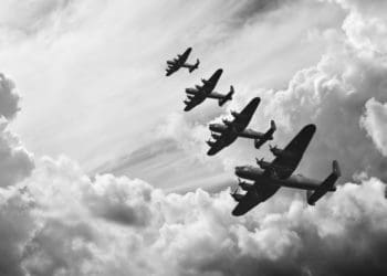 black and white retro image of WW2-era bombers flying in formation