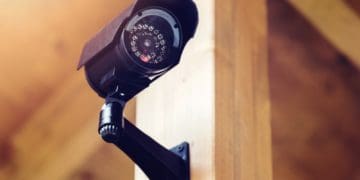black security camera attached to wood beam