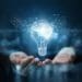 illuminated light bulb with brain inside, in businessman's hands