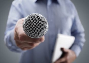 man holding microphone out for comment