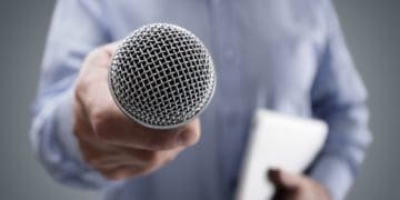 man holding microphone out for comment