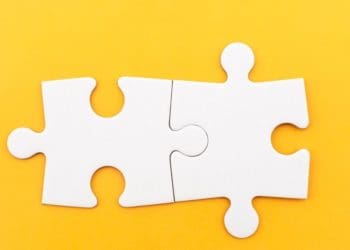 two connected puzzle pieces on yellow background