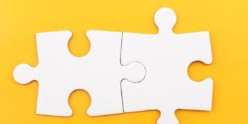 two connected puzzle pieces on yellow background