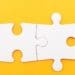 two connected puzzle pieces on yellow background