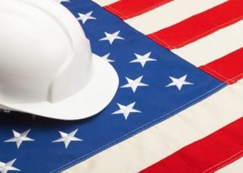 white hard hat on american flag signifying government contractor