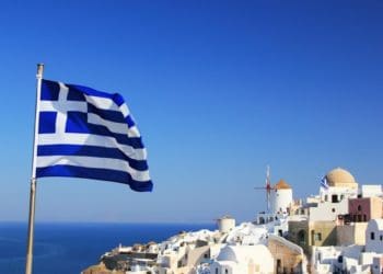 greek flag flying over santorini