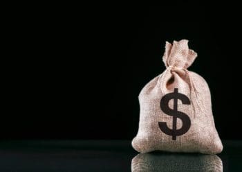 burlap sack of money on black background