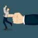 giant hand pushing businessman with one finger