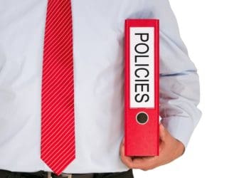 man in red tie holding red policies binder