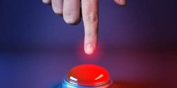 hand prepared to push glowing red button