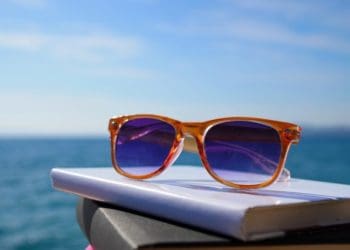 sunglasses on stack of books at the beach