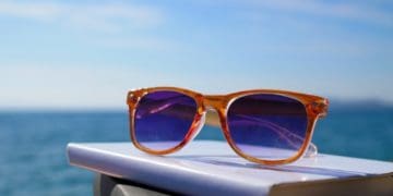 sunglasses on stack of books at the beach