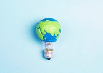 light bulb with earth on blue background
