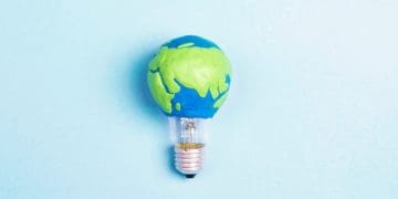 light bulb with earth on blue background