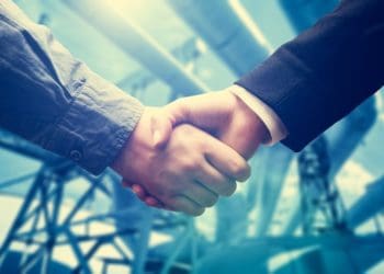 handshake in front of power station