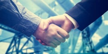 handshake in front of power station