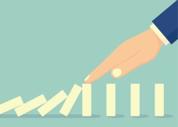 illustration of hand stopping falling dominos