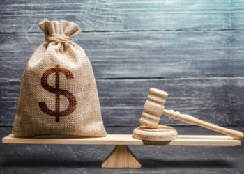 burlap bag of money on scale with judge's gavel