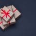 gift boxes in brown paper with red ribbon on black background