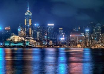 Hong Kong cityscape at night with lights reflecting in Victoria Harbour