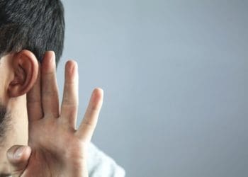 bearded man holding hand behind ear to signal listening