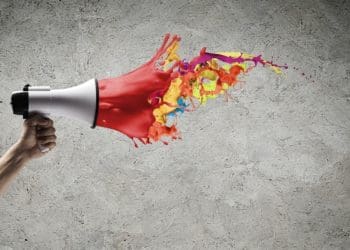 megaphone with paint on gray wall