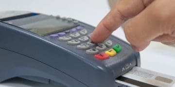 closeup of hand using EDC machine for credit card payment