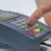 closeup of hand using EDC machine for credit card payment