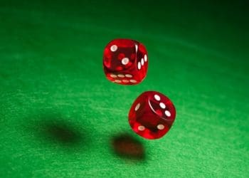 red dice rolling over green felt surface