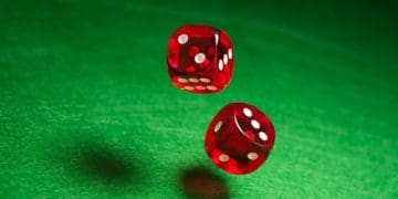 red dice rolling over green felt surface
