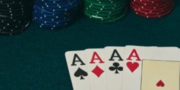 four aces on card table with stacks of poker chips