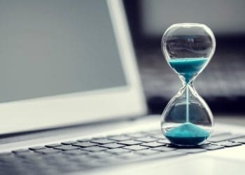 hourglass with blue sand on laptop