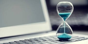 hourglass with blue sand on laptop