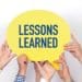 group of co-workers holding "lessons learned" speech bubble
