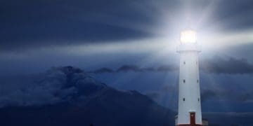 lighthouse shining beacon at night